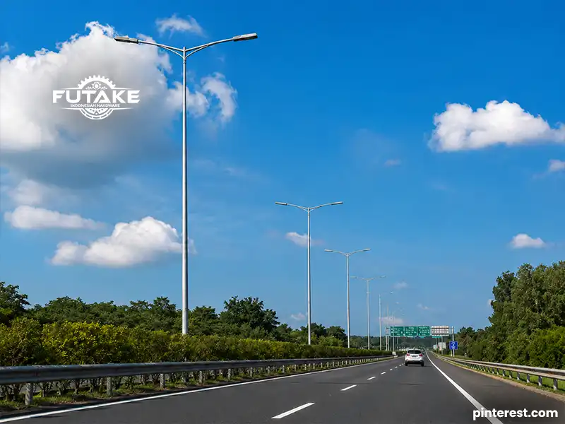 Tiang lampu baja galvanis modern yang terpasang di jalan raya sebagai penerangan umum.