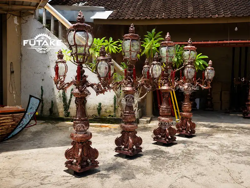 Tiang lampu besi cor dekoratif pada taman kota dengan desain klasik dan elegan.